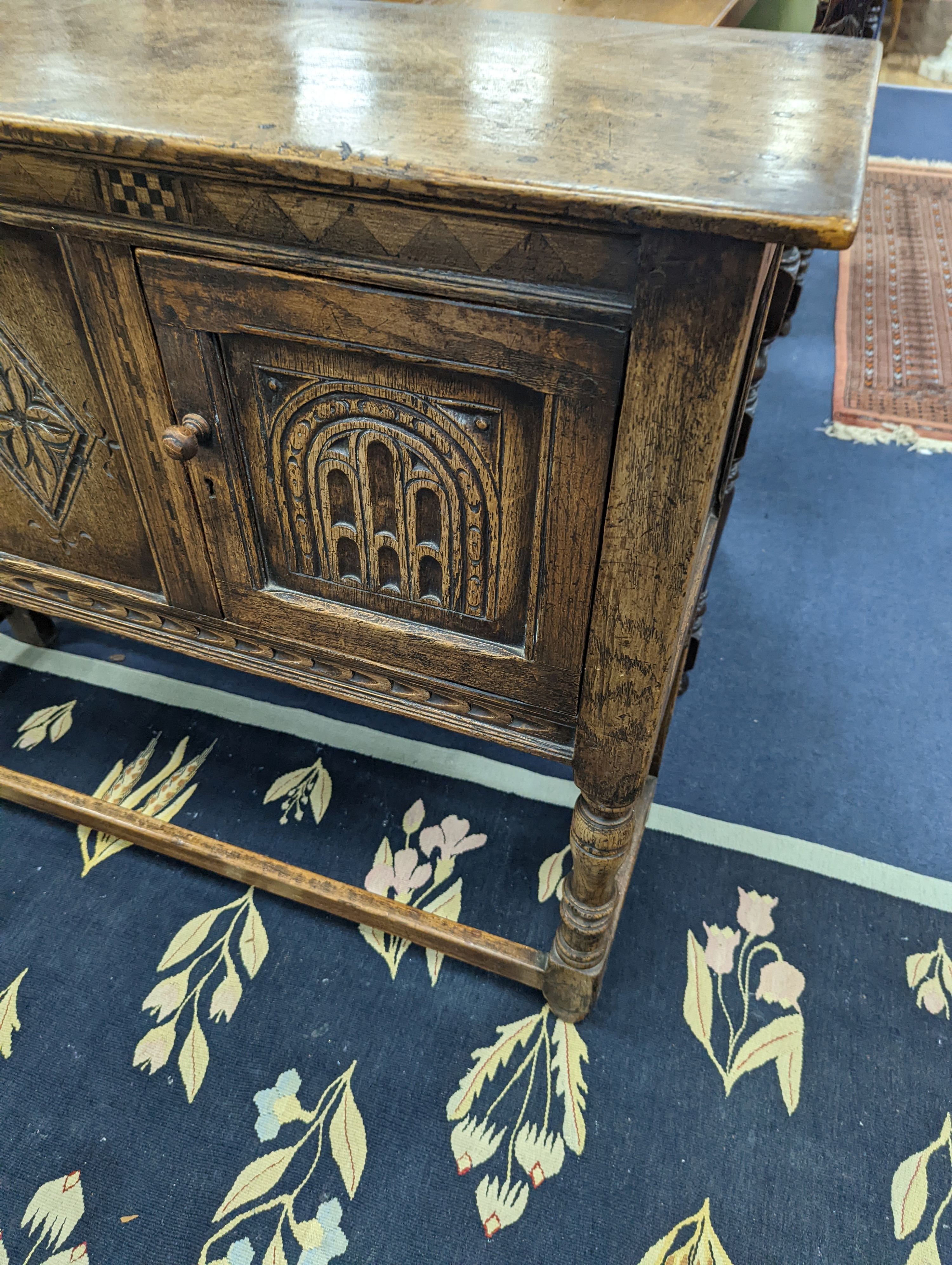An 18th century style carved oak two door side cabinet, width 107cm, depth 35cm, height 86cm